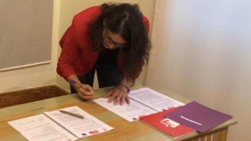 Raquel Romero firmando el acuerdo para el Gobierno